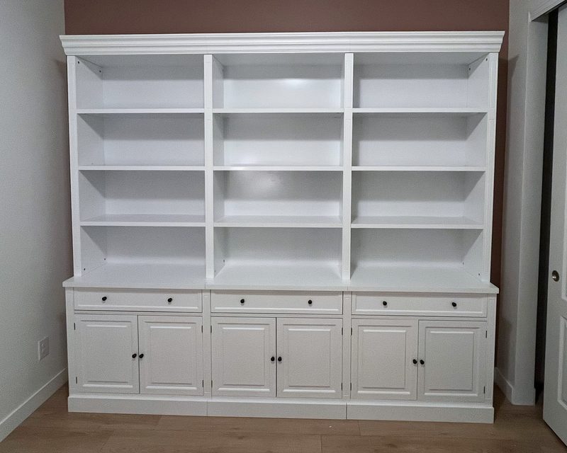 White three-bay library bookcase with open shelves on top and cabinet doors below