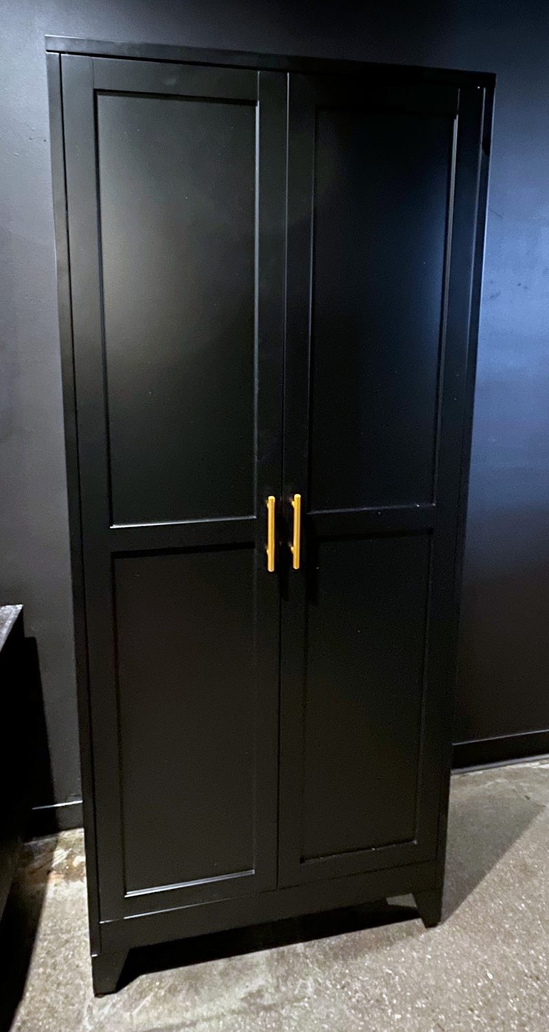 Tall black two-door cabinet with brass handles