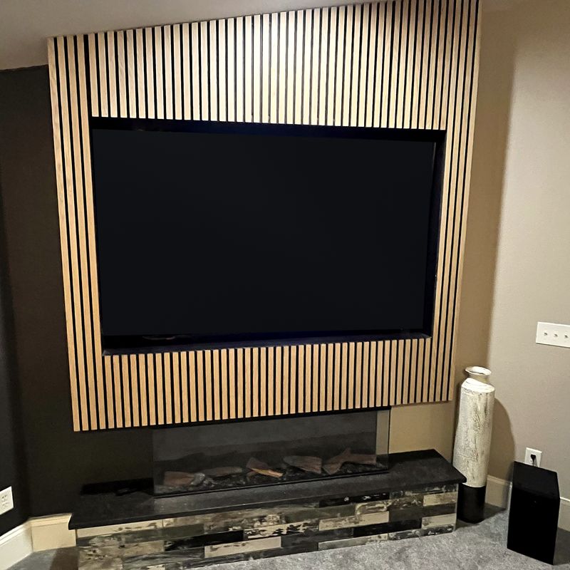 TV installed in a slat wall above a fireplace